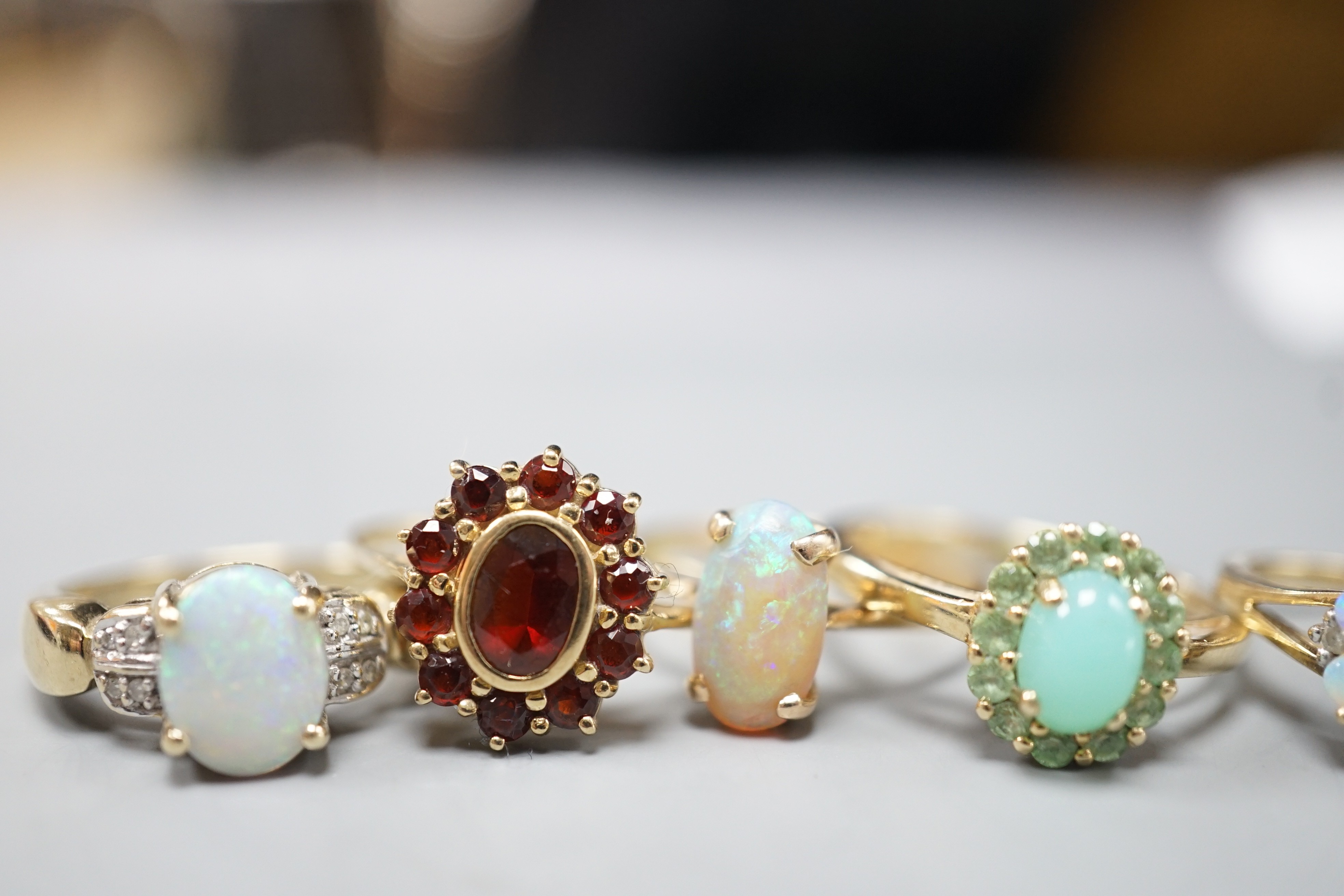 Five assorted modern 9ct gold and gem set dress rings, including white opal and diamond chip cluster, white opal cluster and garnet cluster